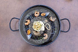 Top view of Arros negre served on a pan in a restaurant