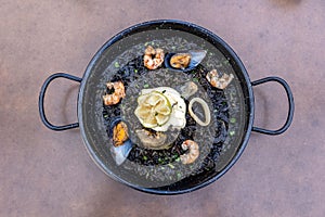 Top view of Arros negre served on a pan in a restaurant photo