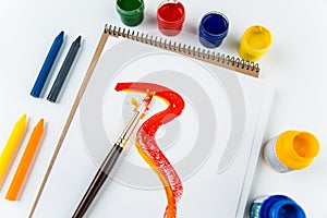 Top view of art album pages, brushes and drawing crayons