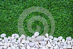 Top view artificial green grass field texture and small white stone abstract background