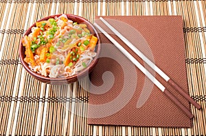 Top view of an Asian bowl of rice noodle and vegetable seasoning