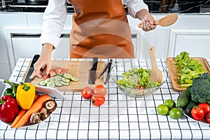 Top view of asian housewife holding ladle and touching touchscreen on tablet to researching new recipes