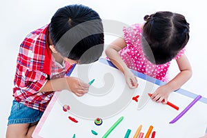 Top view. Asian kids playing with play clay on table. Strengthen photo