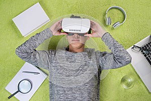 Top view of asian man wearing virtual reality goggles. Man lying