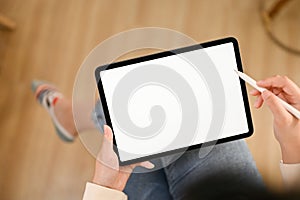 Top view of an Asian woman using her digital tablet in the living room