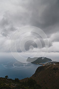 A top view at Asos village and Assos peninsula from a road during the bad weather conditions, thunderstorm and rain, with low dark