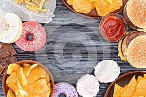 top view of assorted sweets and junk food on wooden table