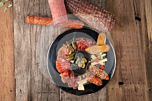 Top view of an assortment of cold appetizers served on a black plate