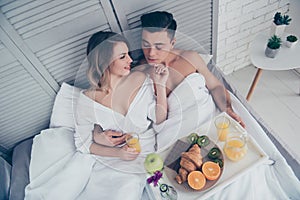 Top view of attractive couple having breakfast in bad, embracing