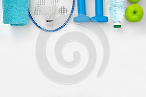 Top view on a attributes of a healthy lifestyle: food, sports equipment on a white background with copy space