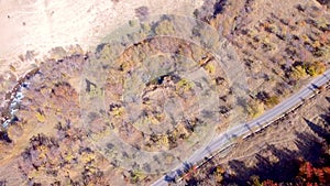 Top view of autumn forest with road