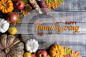 Top view of  Autumn maple leaves with Pumpkin, apple, corn and red berries on old wooden background. Thanksgiving day concept