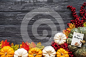 Top view of Autumn maple leaves with Pumpkin and red berries on old wooden backgound.