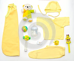 Top view of baby girl yellow clothes and toy stuff