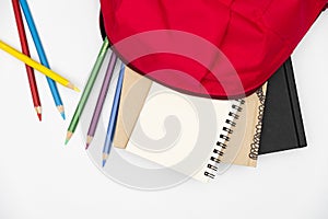 Top view- backpack and school stationery on white background