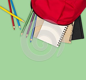 Top view- backpack and school stationery on white background