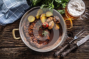 Top view of baked pork nech with potaties served in metallic vintage bowl and beer photo