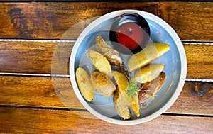 Top View Baked potato wedges with shredded onion and herbs and tomato sauce