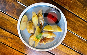 Top View Baked potato wedges with shredded onion and herbs and tomato sauce