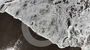 Top view of balis beach with a wave and black sand photo