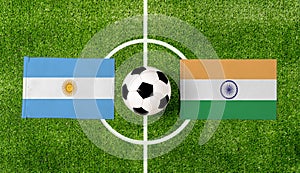 Top view ball with Argentina vs. India flags match on green soccer field