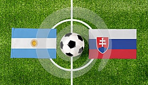 Pohľad zhora na loptu s vlajkami Argentína vs. Slovensko na zelenom futbalovom ihrisku