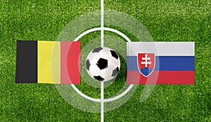 Pohľad zhora na loptu s vlajkami Belgicka vs. Slovensko na zelenom futbalovom ihrisku