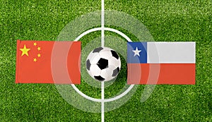 Top view ball with China vs. Chile flags match on green soccer field