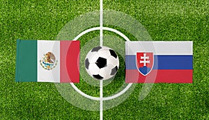 Top view ball with Mexico vs. Slovakia flags match on green football field