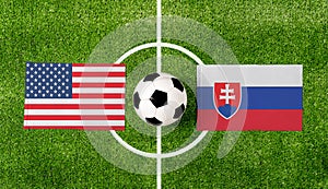 Pohľad zhora na loptu so zápasom vlajok USA vs. Slovensko na zelenom futbalovom ihrisku