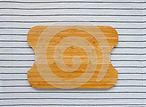 Top view of bamboo chopping board, isolated on white linen striped kitchen towel. Empty board, for food preparation mock up