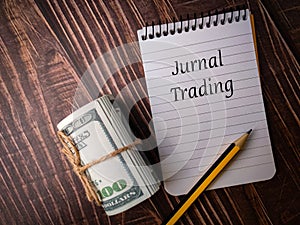Top view banknotes,notebook and pencil with text Jurnal Trading photo