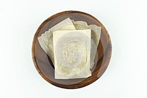 Top view of barley tea paper envelopes in wooden bowl