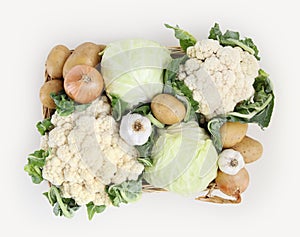 Top view basket of cabbage, cauliflowers, potatoes, garlic and o