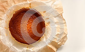 Top view of Basque burnt cheesecake on baking paper on white background.