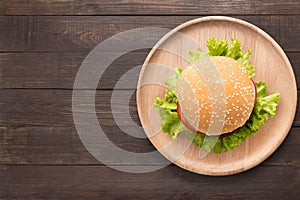 Top view BBQ burger on wooden dish on wooden background.