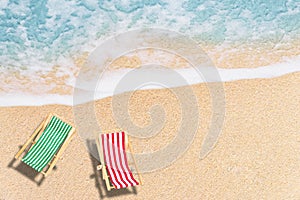 Top view  of Beach chairs on sand beach with white wave and blue sea.