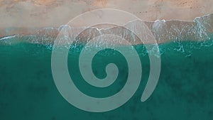 Top view beach and ocean waves transparent green sea waters. Drone view of beautiful turquoise sea waves breaking on