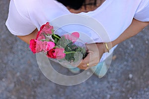 Top view of a beautiful bouquet of red roses is held by middle aged woman. Valentine`s day or ramantic love concept.