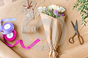 top view of beautiful bouquet of tulips, scissors, ribbons and envelopes with rope