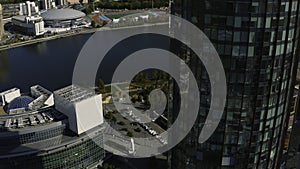 Top view of beautiful business skyscrapers by river. Stock footage. High-rise offices in business center of modern city