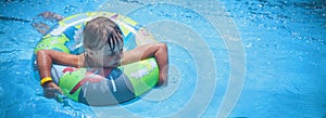 Top view of beautiful child girl in swimming pool relax swim on inflatable ring. Summer holiday, vacation and happy childhood.