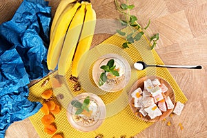 Top view of a beautiful colorful set of bananas, Turkish Delight, and sweet fruit desserts on a light wooden background.