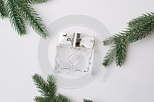 Top view of a beautiful jar of perfume surrounded by Christmas tree branches. Capacity. place for text. the brand. White