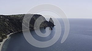 Top view of beautiful mountain coast with clear sky and horizon. Action. Picturesque seascape with mountains on coast