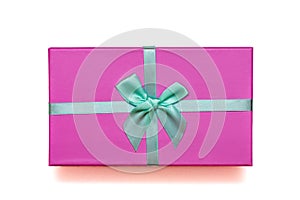 Top view of beautiful pink gift box with turquoise bow on isolated white background. Christmas concept. Flat lay