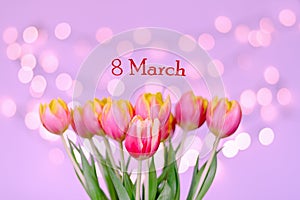 Top view of beautiful pink, yellow tulips on blue background with bokeh. Greeting card. 8 March. Mother`s Day. Happy Women.