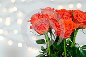 Top view of beautiful red roses bouquet against white background with bokeh. Greeting card. Mother\'s Day. Happy Woman Day