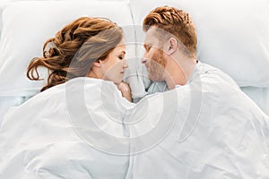 top view of beautiful redhead couple sleeping face to face
