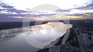 Top view of beautiful sunset over river and city in summer. Clip. Reflection of sunset in river near summer city. Summer